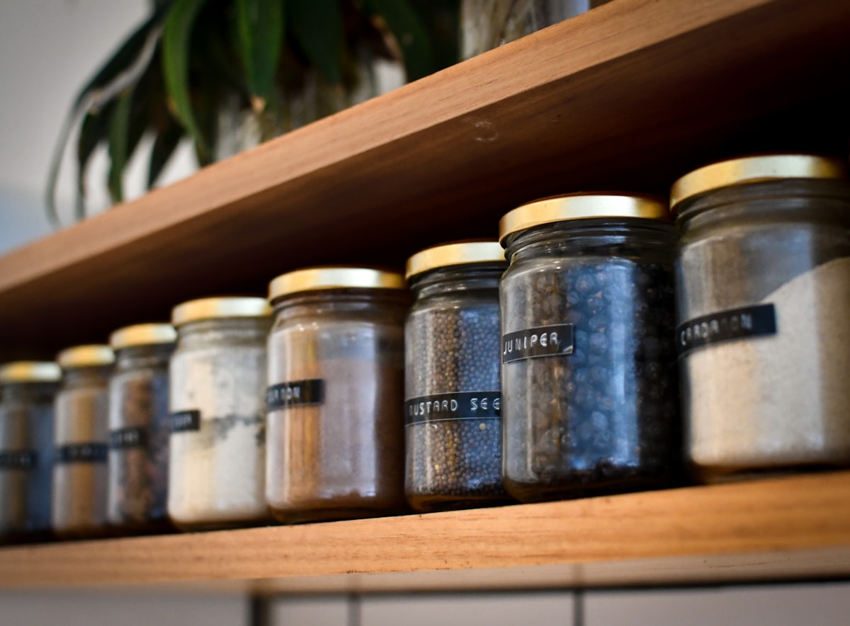 A close-up shelf filled with small jars of different spices.