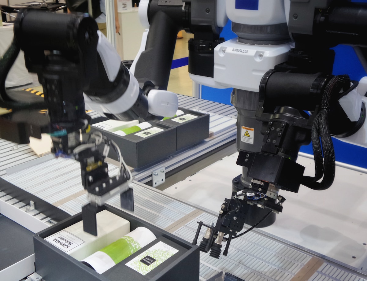 An industrial robotic arm in a factory in monochrome.