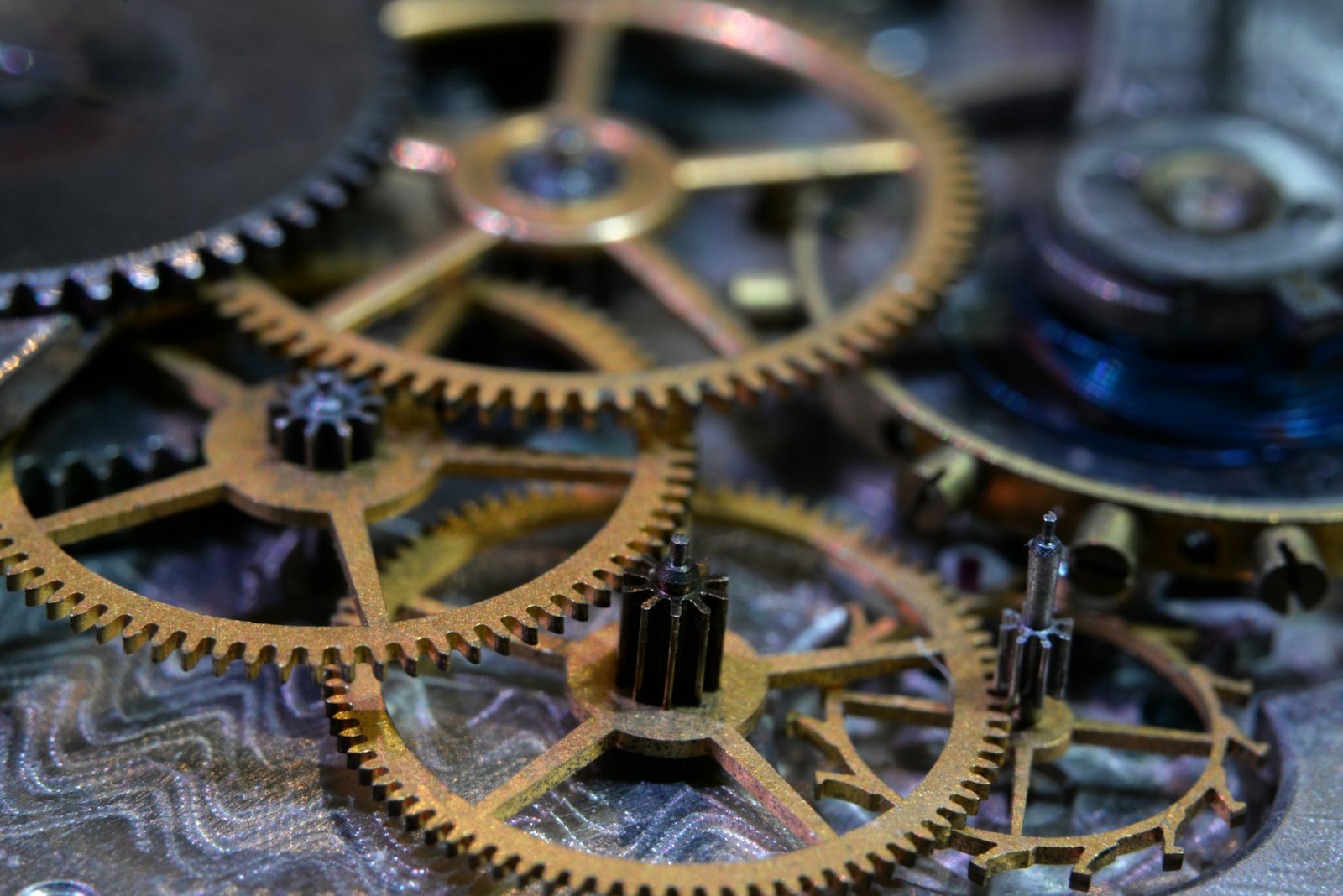 Macro photograph of gears from a pocket-watch movement, lit warmly.
